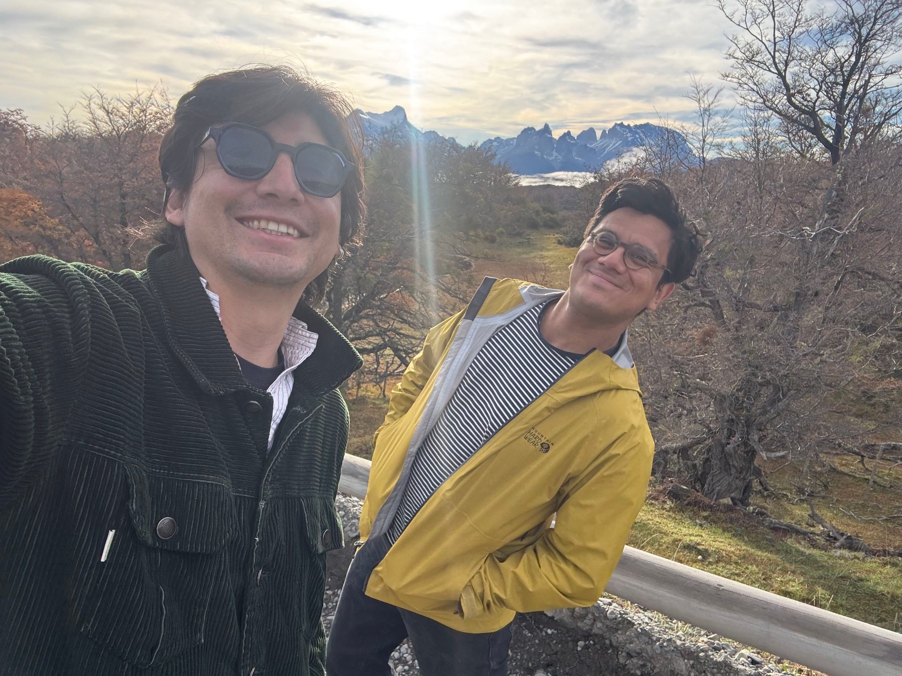 Andrés and a friend outdoors with mountains in the distance