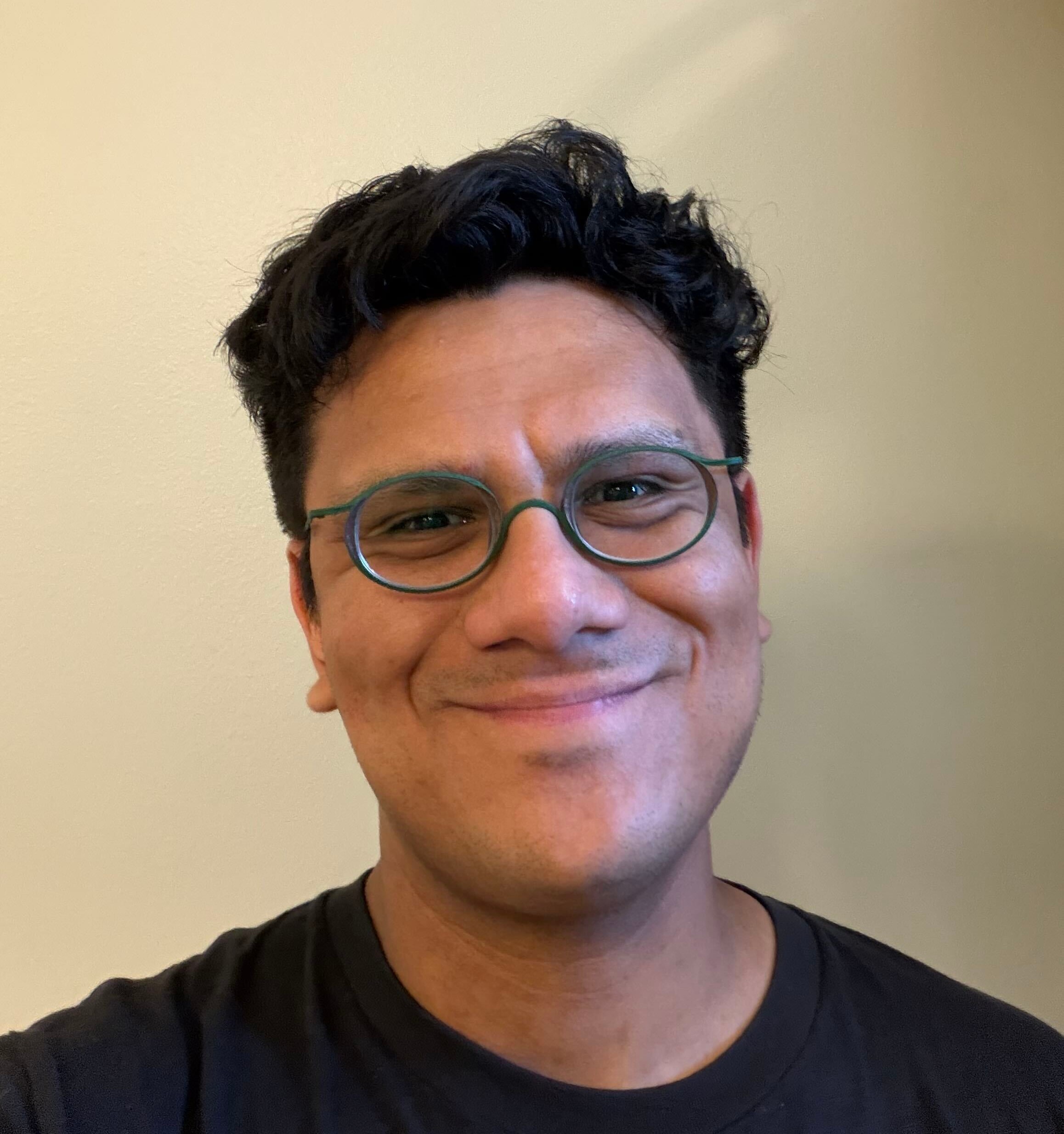 Andrés Nigenda smiling and wearing green glasses